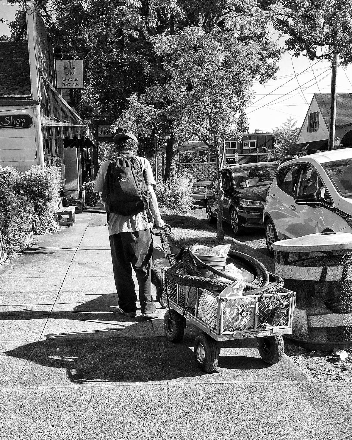 Black and white photograph of a fifth wheel trailer parked near a deck outside of a house in Portland Oregon